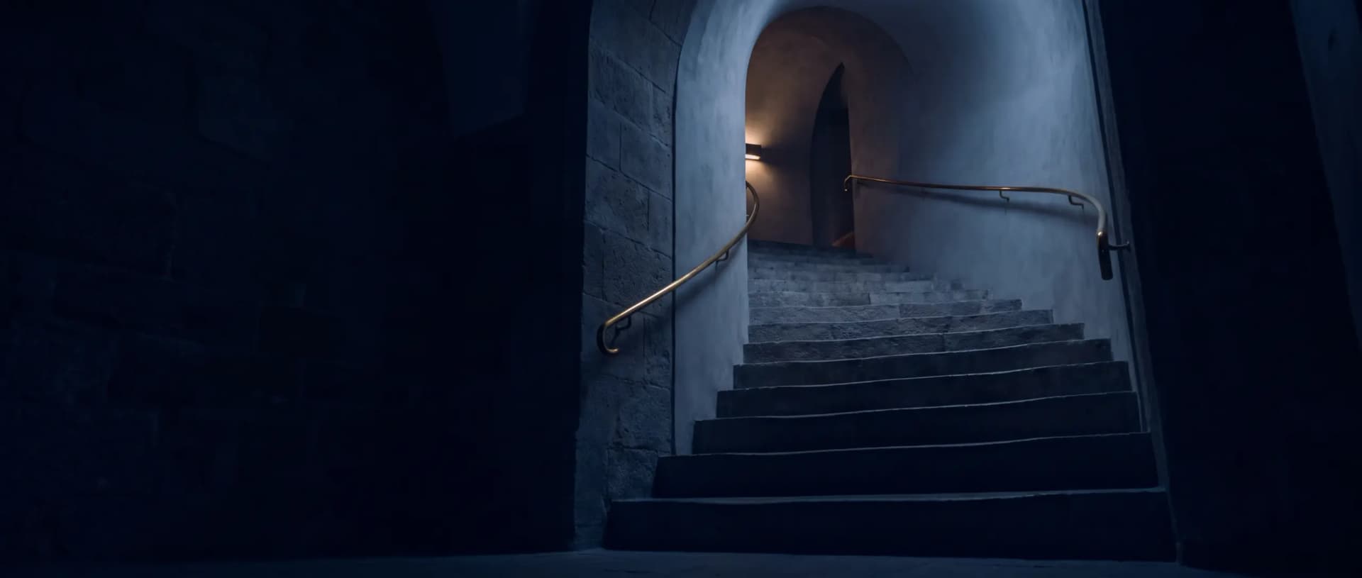 Escalier de pierre à main courante en laiton dans une douce lumière nocturne